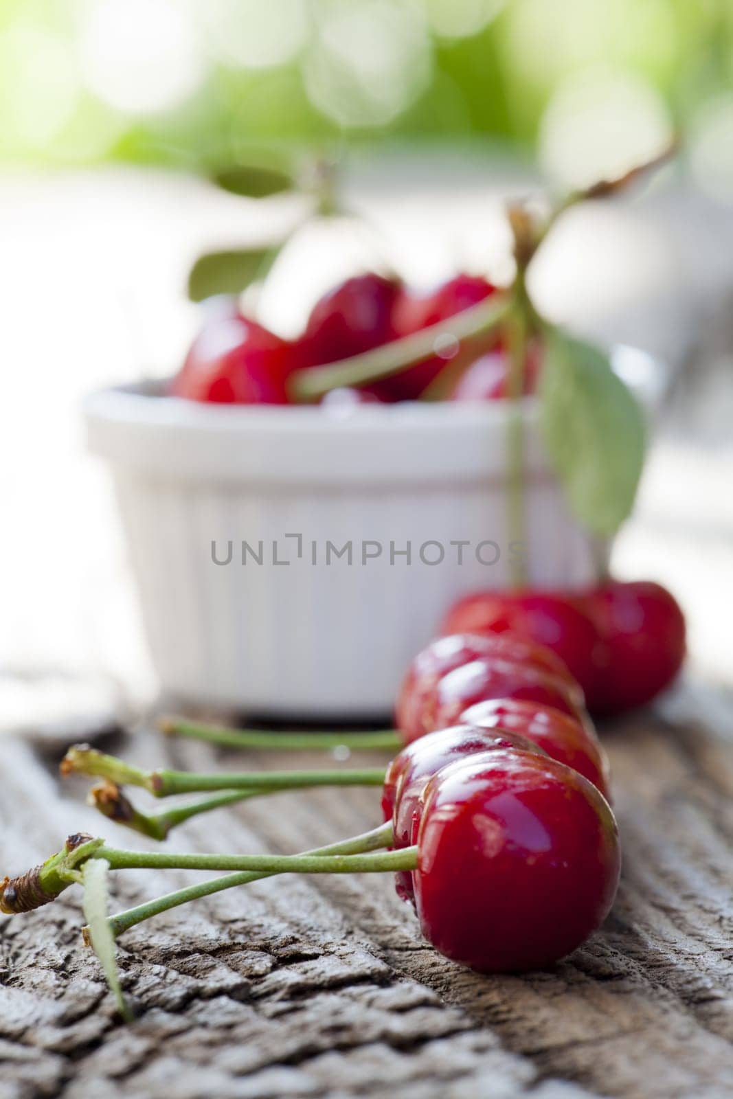 Ripe cherries in a row on the wooden table