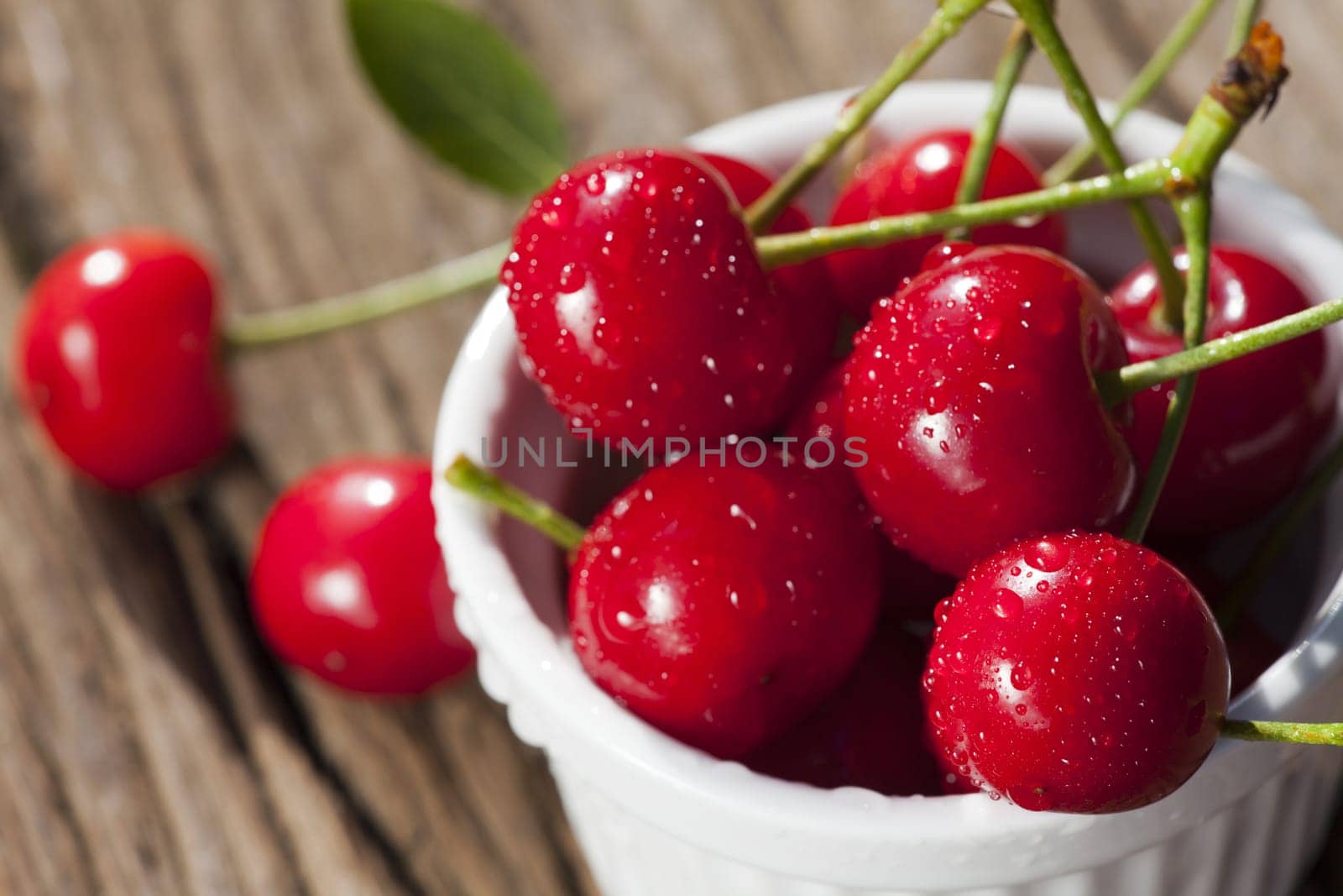 Cherries in a bowl and on the table