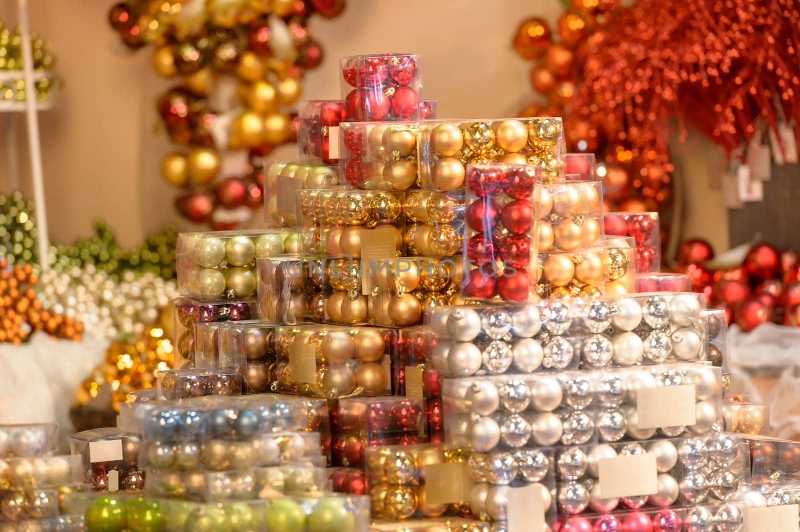 Pile of shiny Christmas balls in plastic boxes at shop