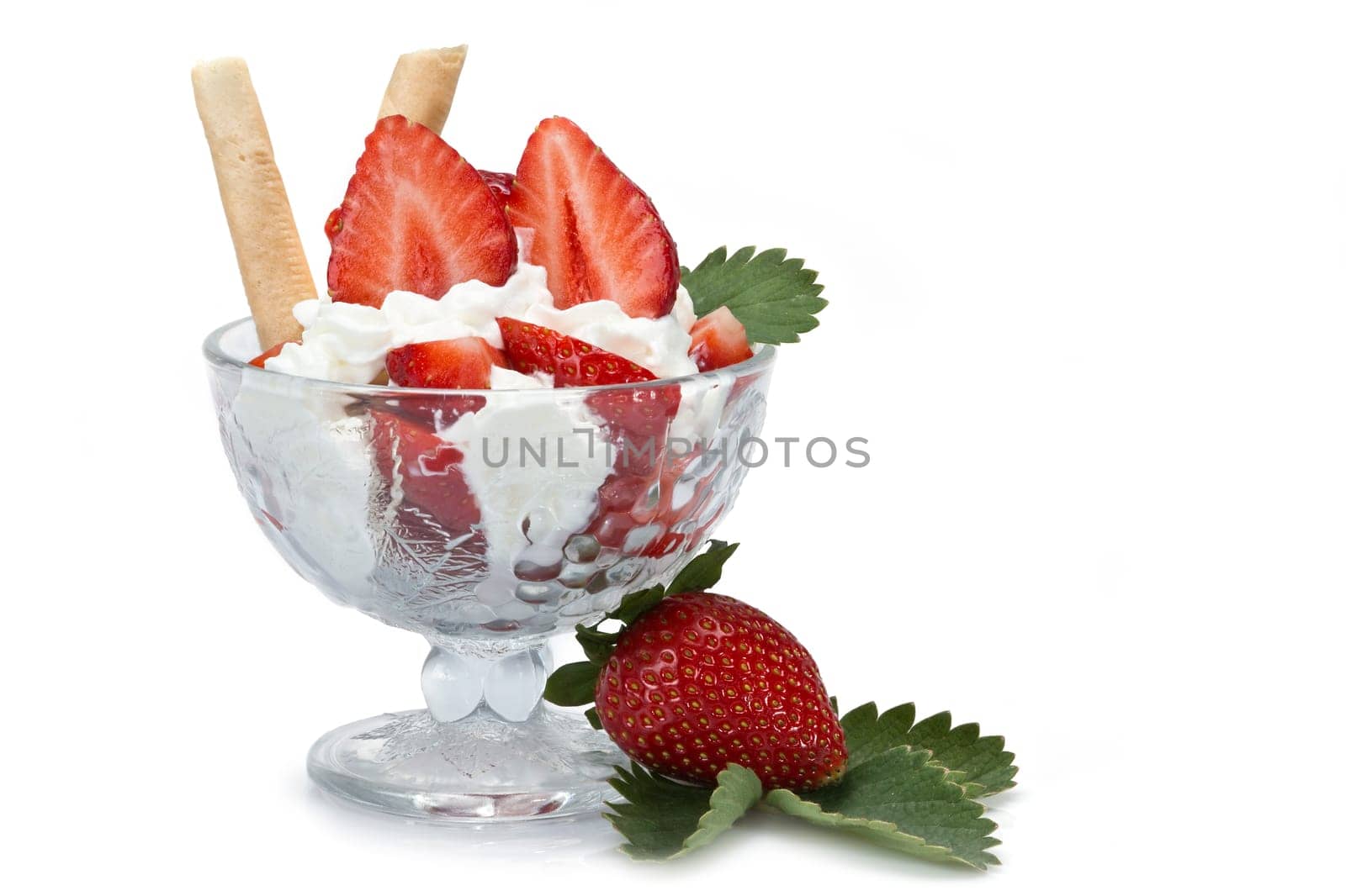 Strawberries and whipped cream cup isolated over a white background.