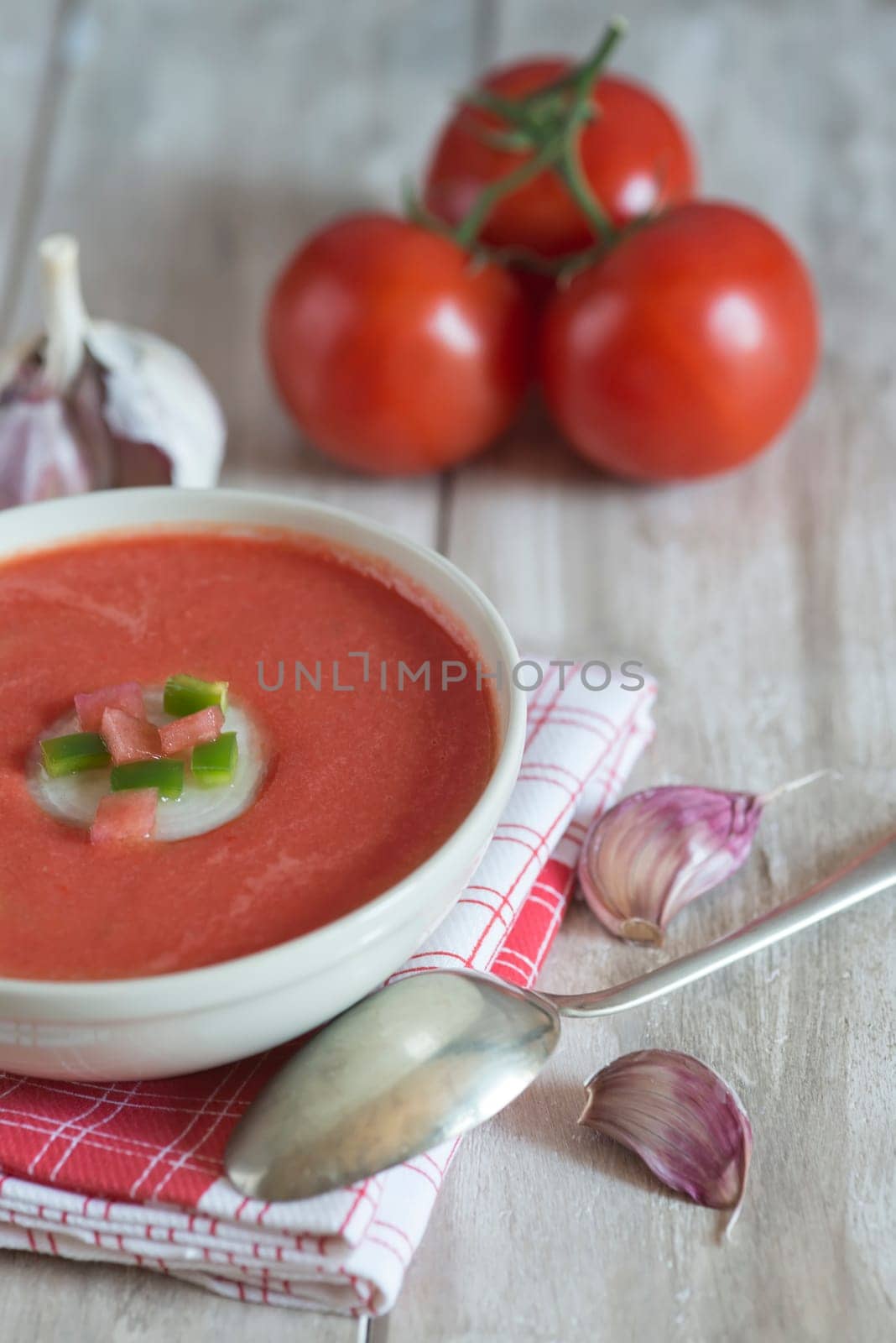 A bowl with gazpacho soup on a wooden background