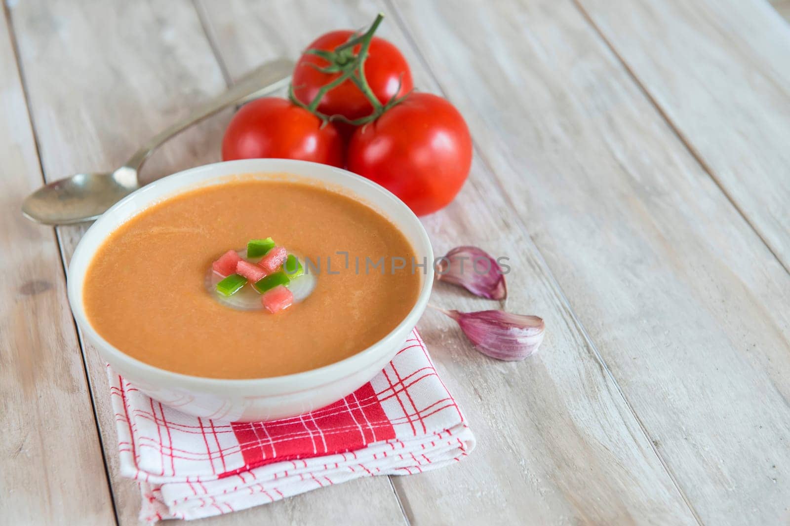 A bowl with gazpacho soup on a wooden background