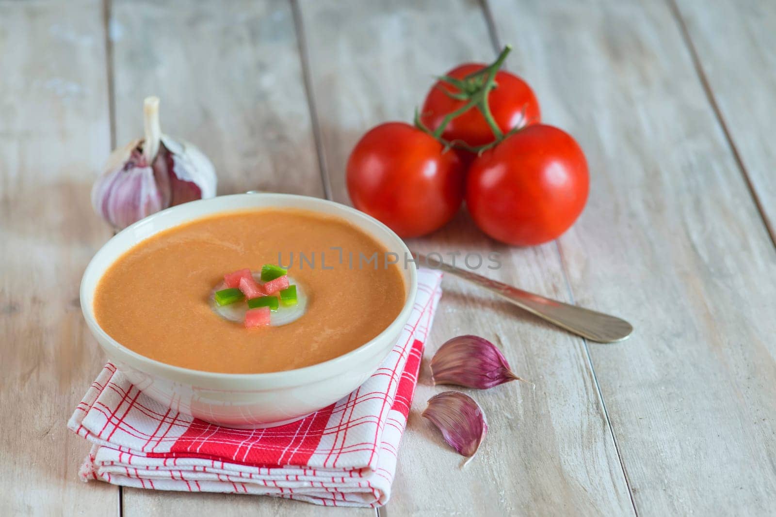 A bowl with gazpacho soup on a wooden background