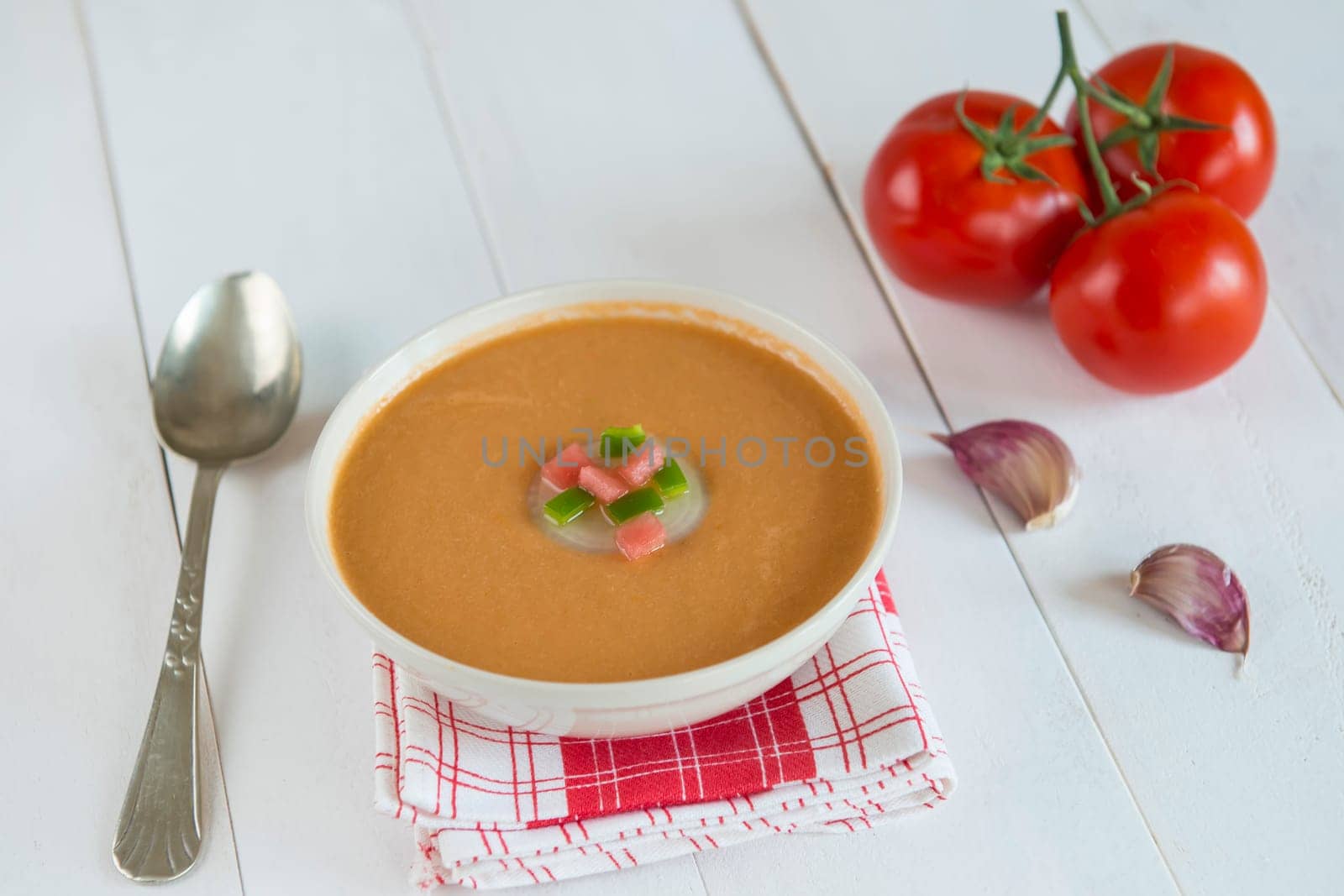 A bowl with gazpacho soup on a wooden background