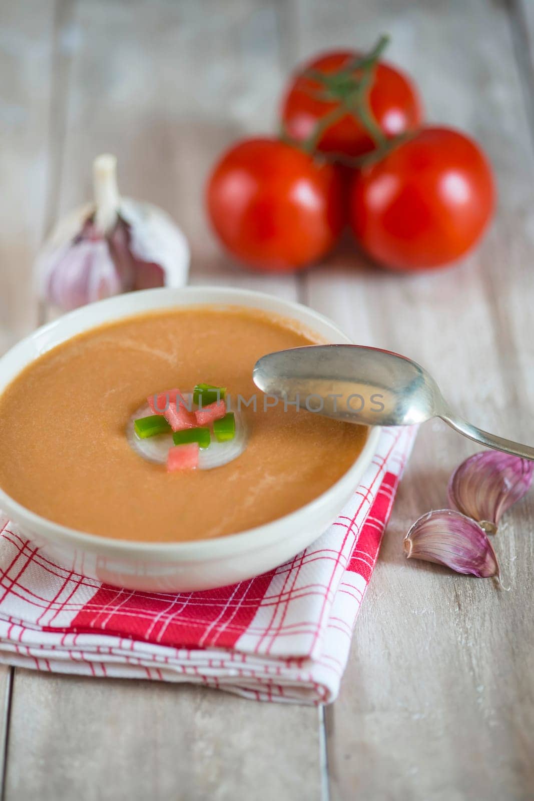 A bowl with gazpacho soup on a wooden background