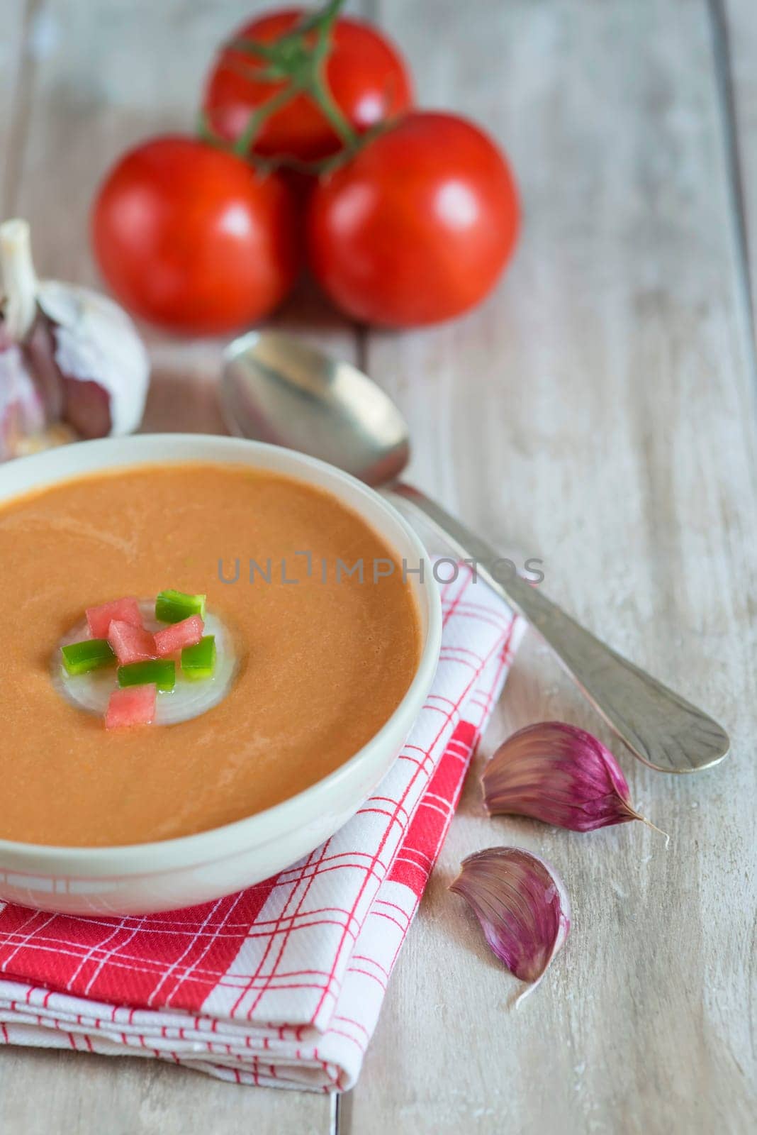 A bowl with gazpacho soup on a wooden background