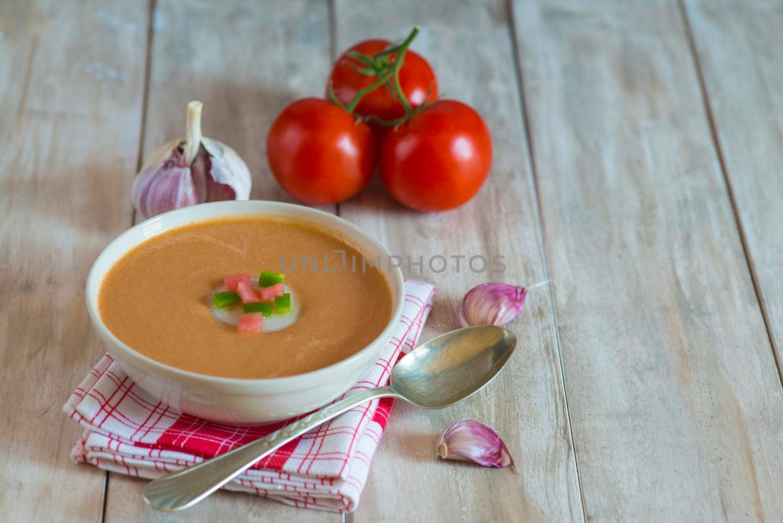A bowl with gazpacho soup on a wooden background
