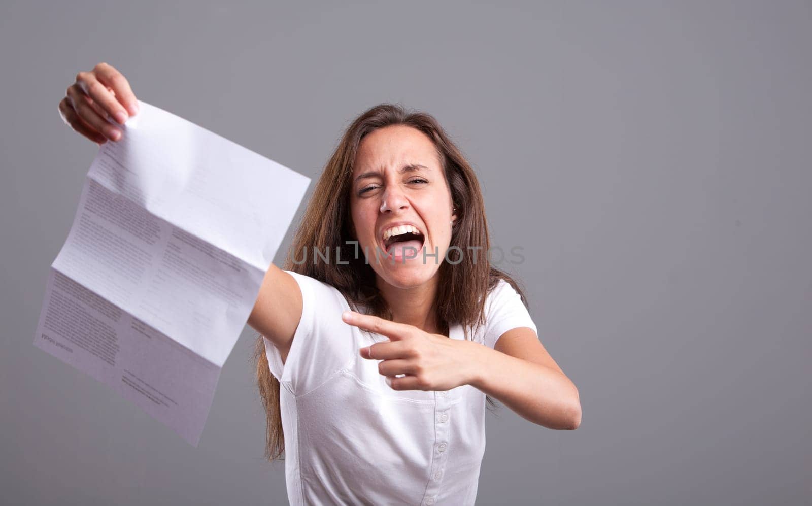 Angry girl pointing out a  letter containing bad news or something upsetting