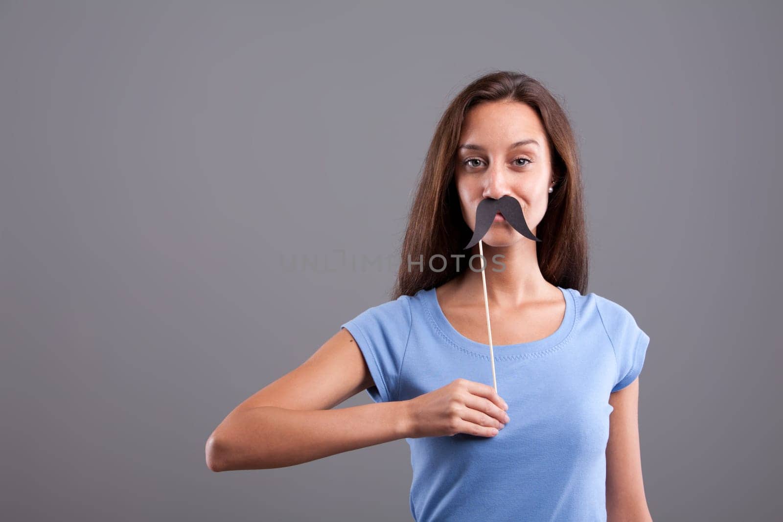 Very cute girl with a sly smile and fake mustache
