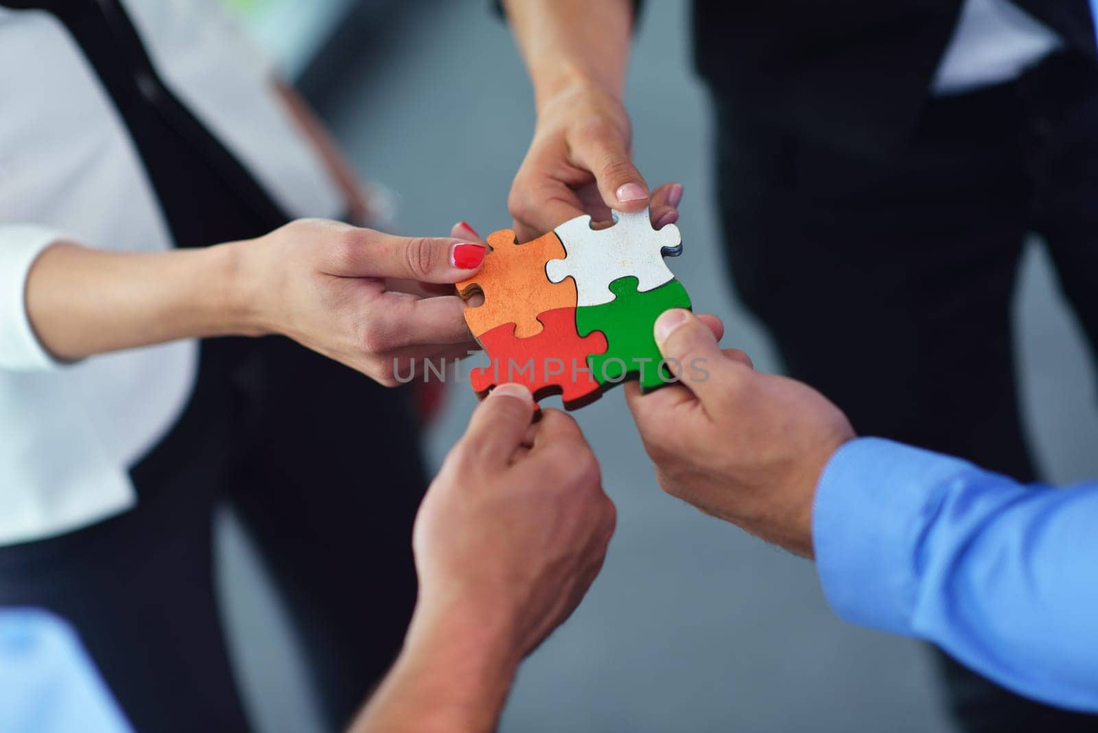 Group of business people assembling jigsaw puzzle and represent team support and help concept