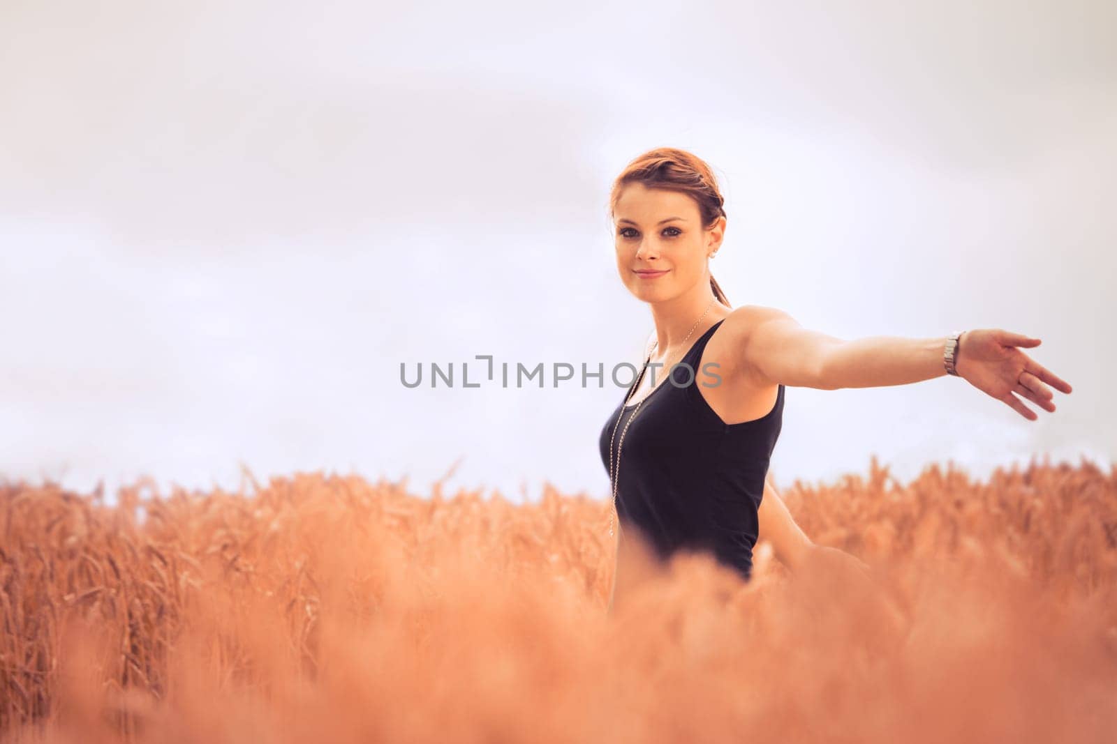 Natural picture of a good looking and lucky girl walking through a meadow. With a lot of copyspace.