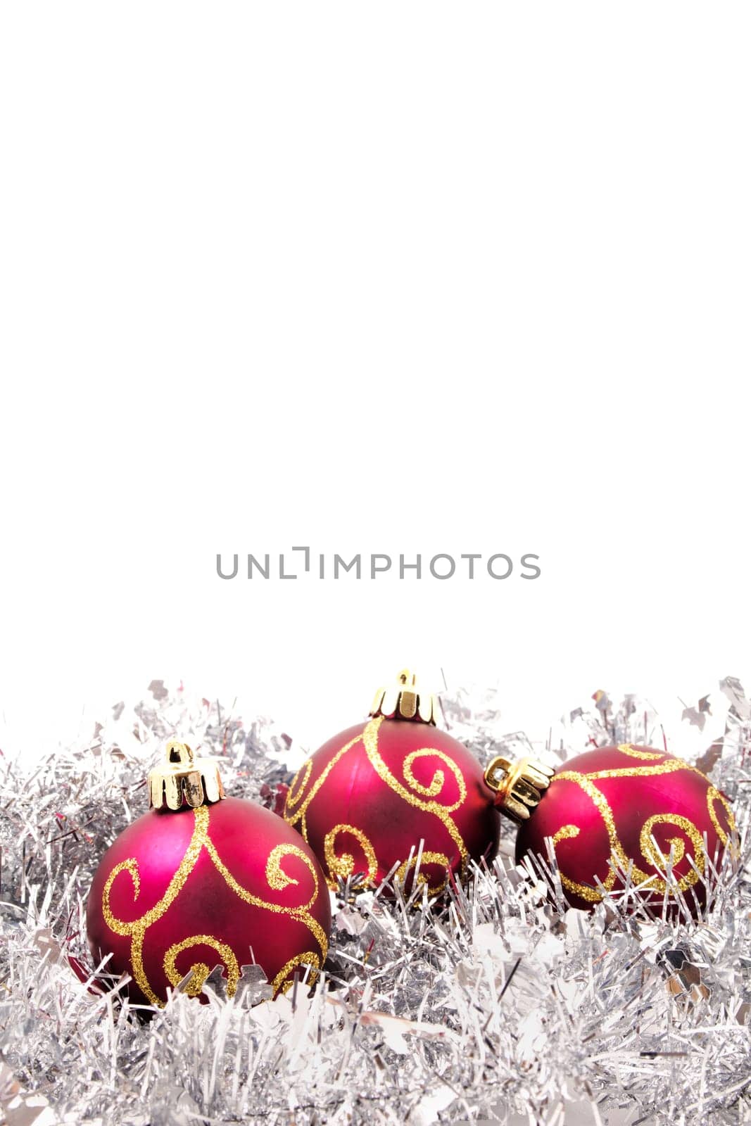 red and gold christmas baubles on a bed of silver tinsel with copy space at the top