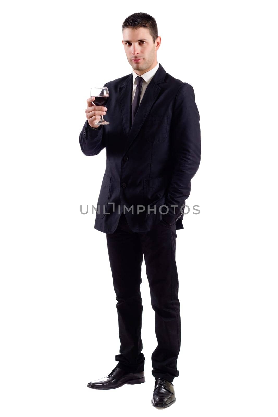 View of a young man holding a red glass of fine wine isolated on white studio background.