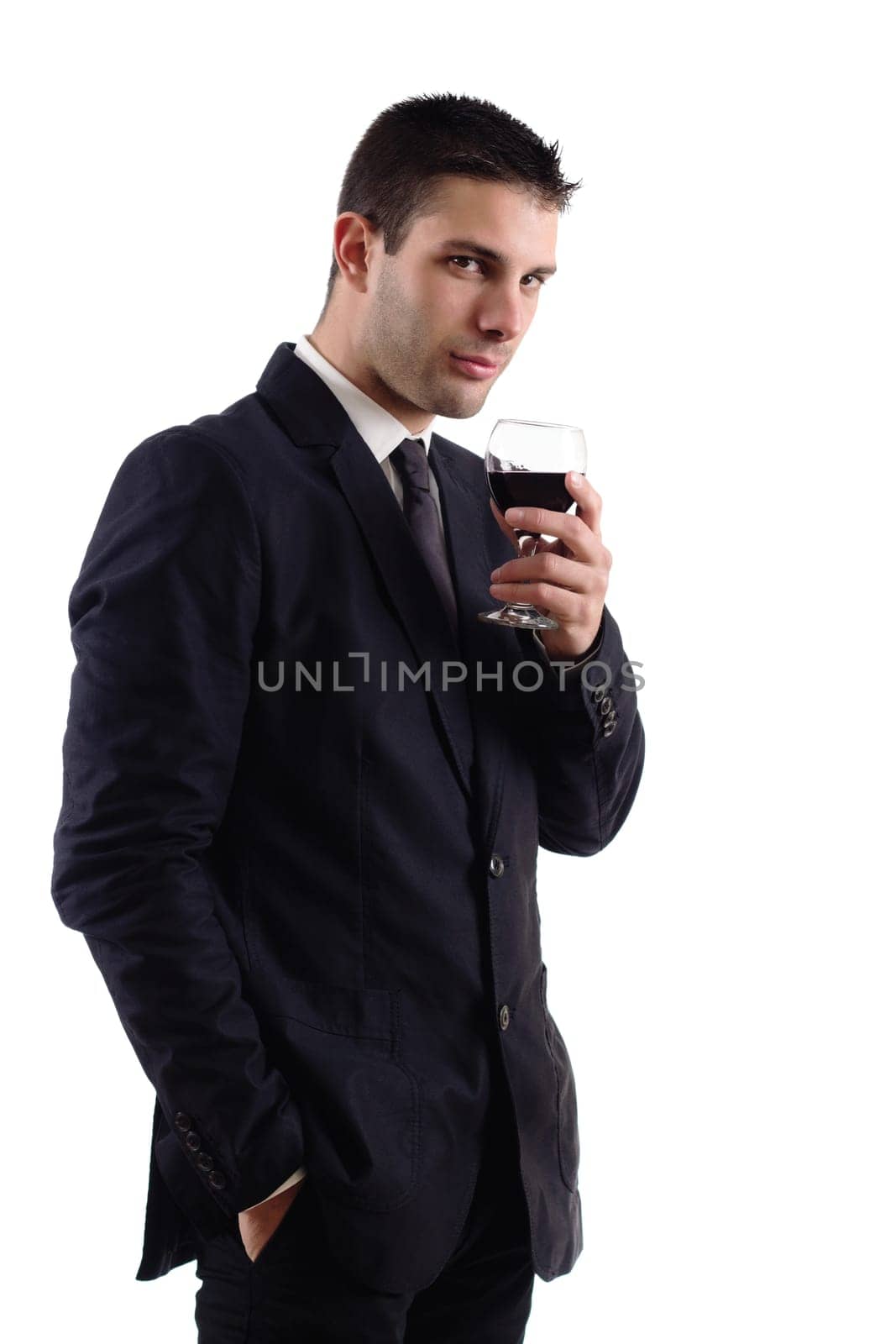 View of a young man holding a red glass of fine wine isolated on white studio background.