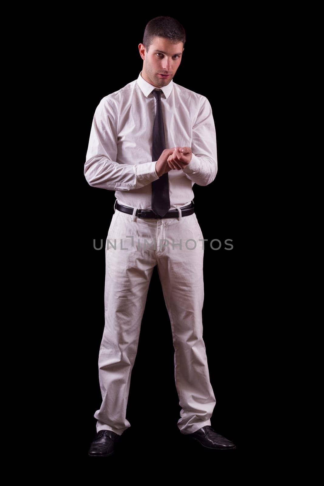 View of a handsome young man on a white suit with tie isolated on a black background.