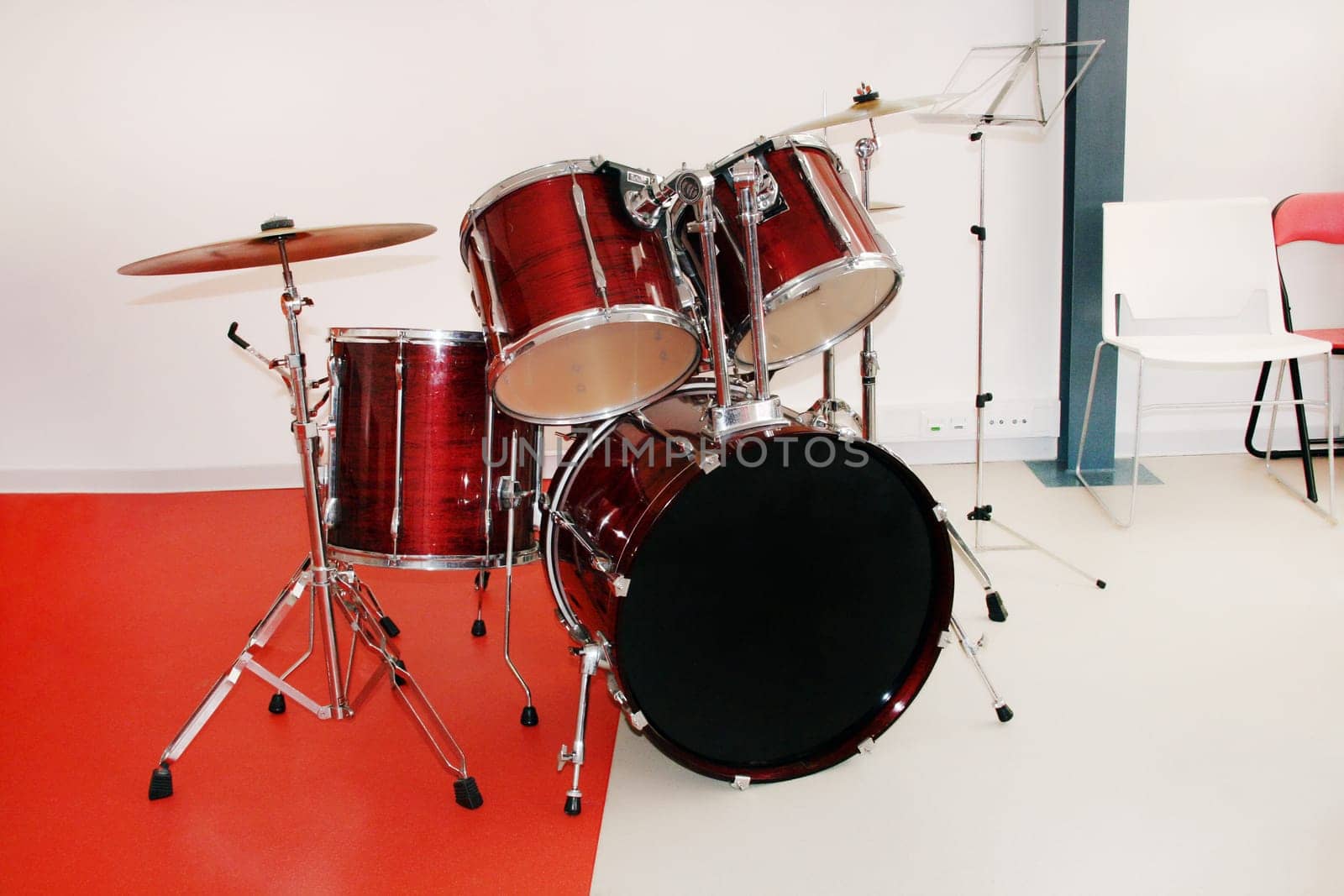 View of a red drum set inside a room.