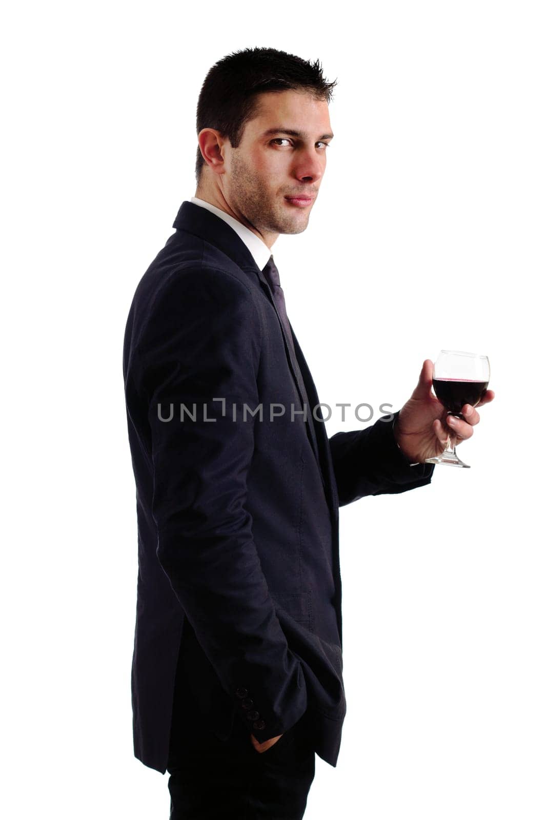 View of a young man holding a red glass of fine wine isolated on white studio background.