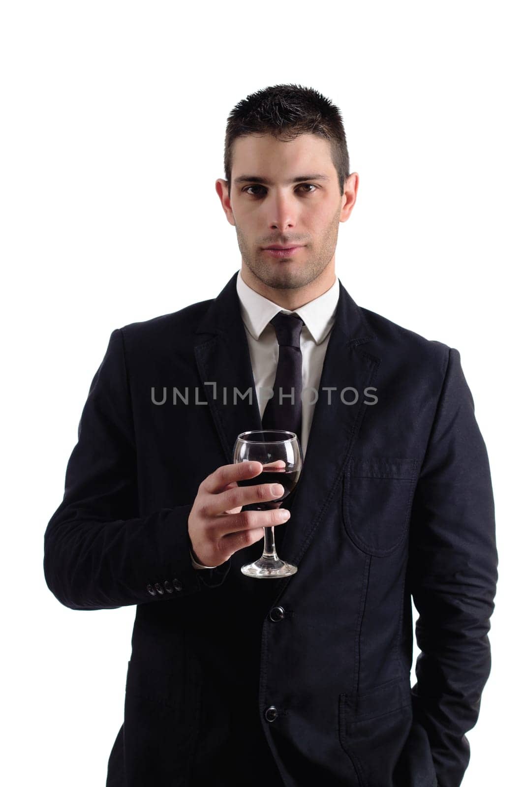 View of a young man holding a red glass of fine wine isolated on white studio background.