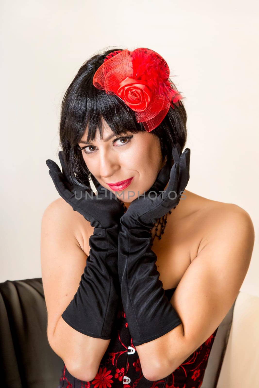 View of a beautiful young woman with a vintage look posing on a sofa.