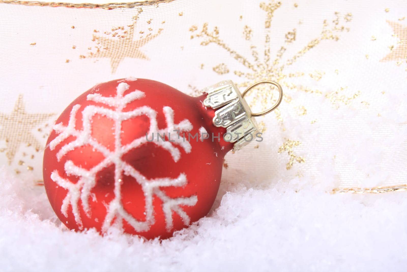 red Christmas bauble with white pattern,design on artificial snow