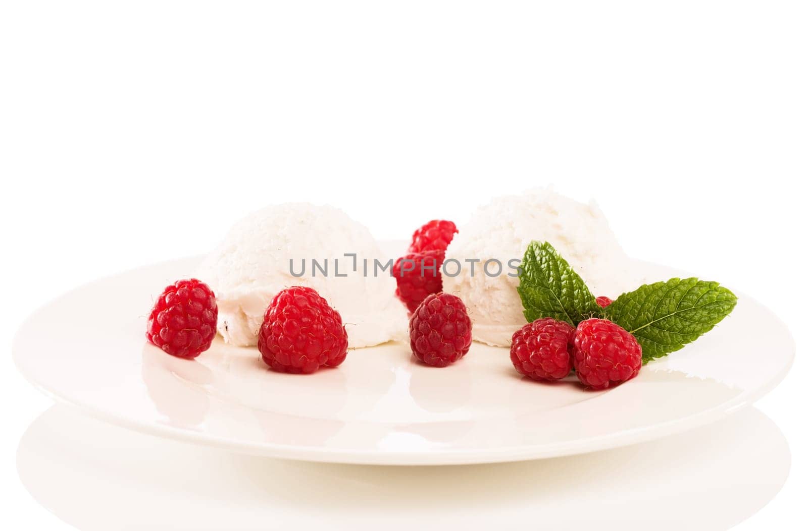 Vanilla ice cream with raspberries on a plate against a white background
