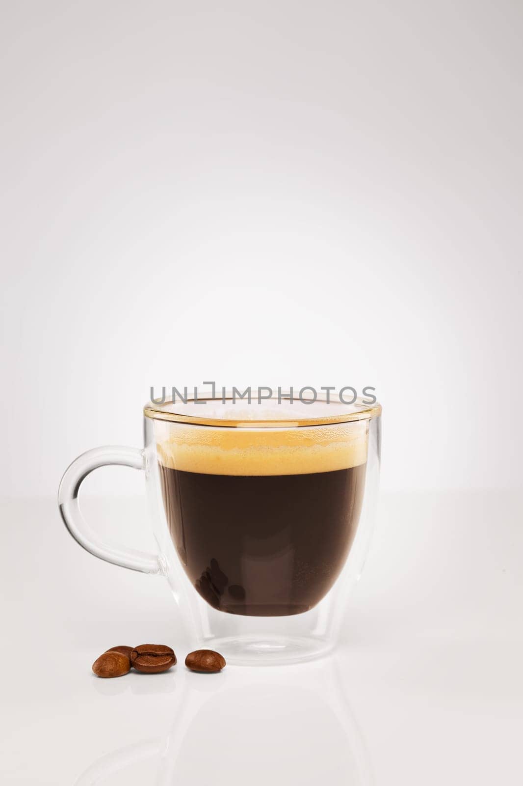 Espresso with coffee beans on grey background