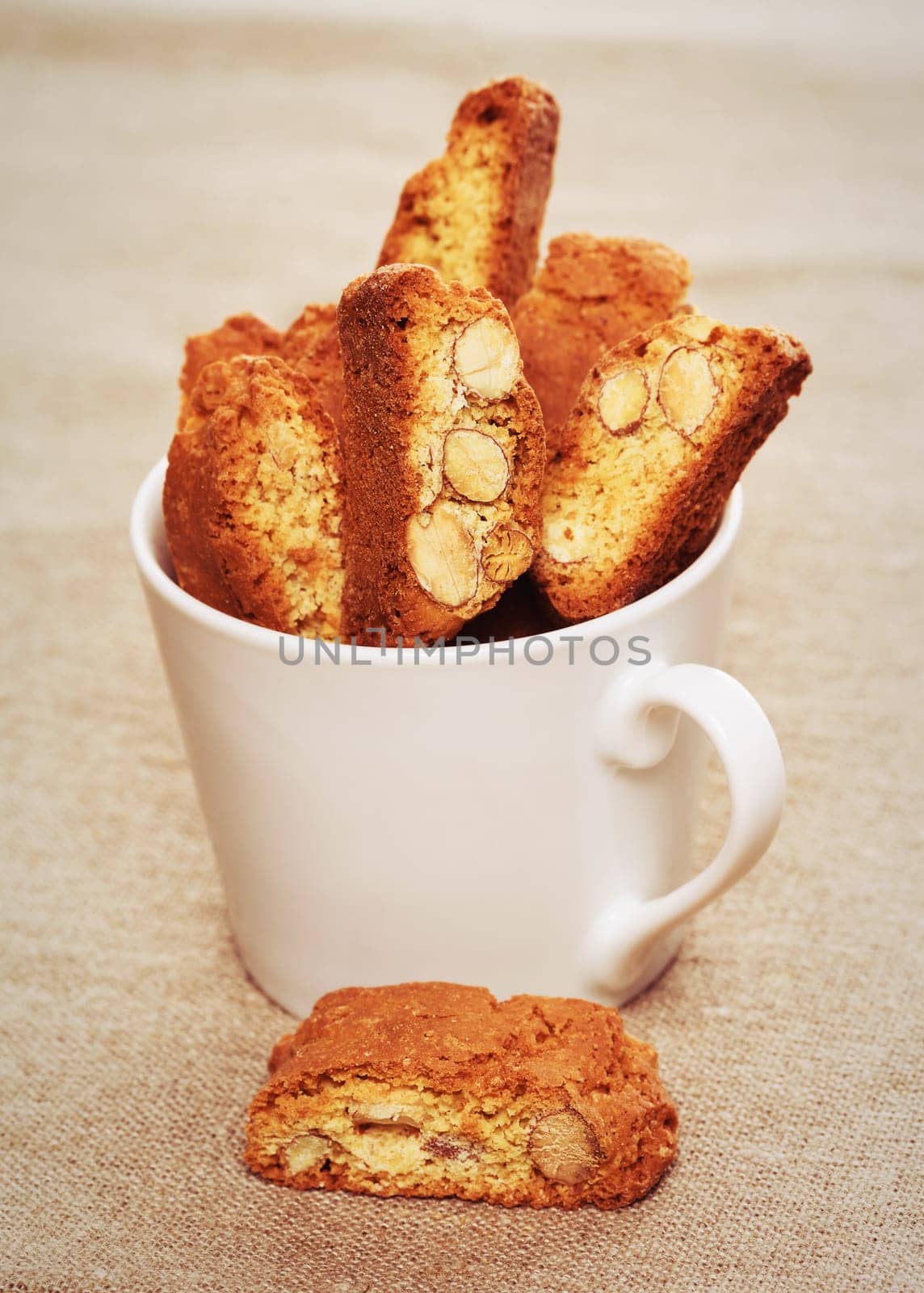 Cantuccini biscuits in a coffee cup on linen fabric