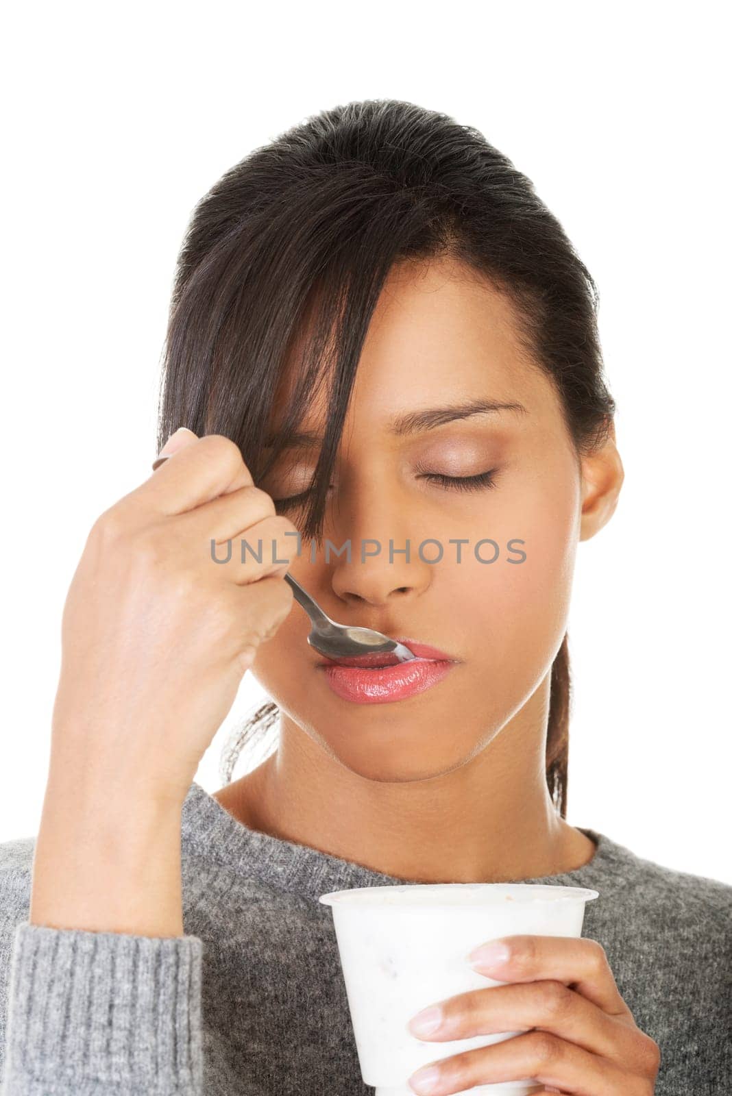 Young beautiful woman eating yogurt as healthy breakfast or snack. Isolated on white