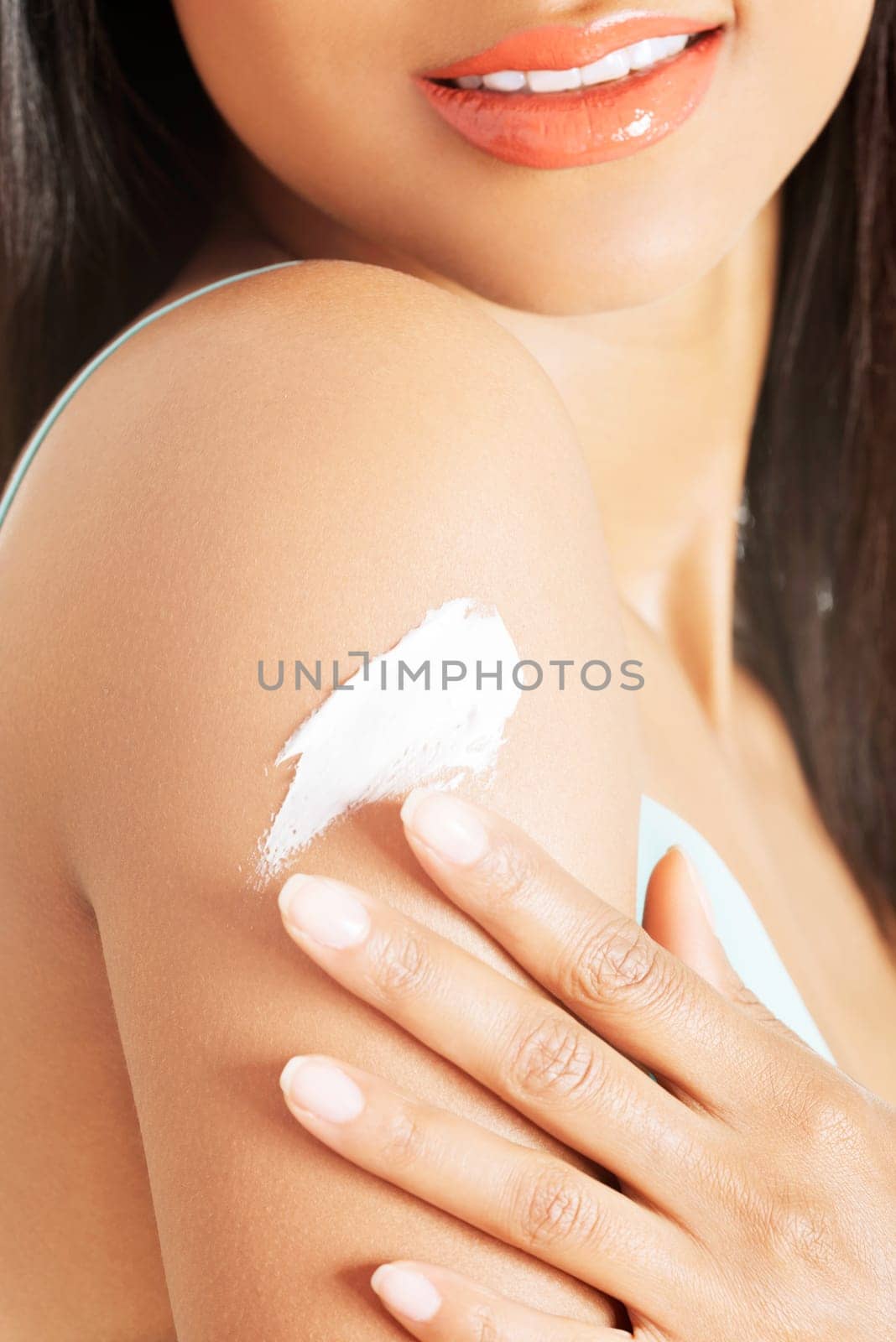 Beautiful woman with healthy skin applying cosmetic cream on a clean fresh arm