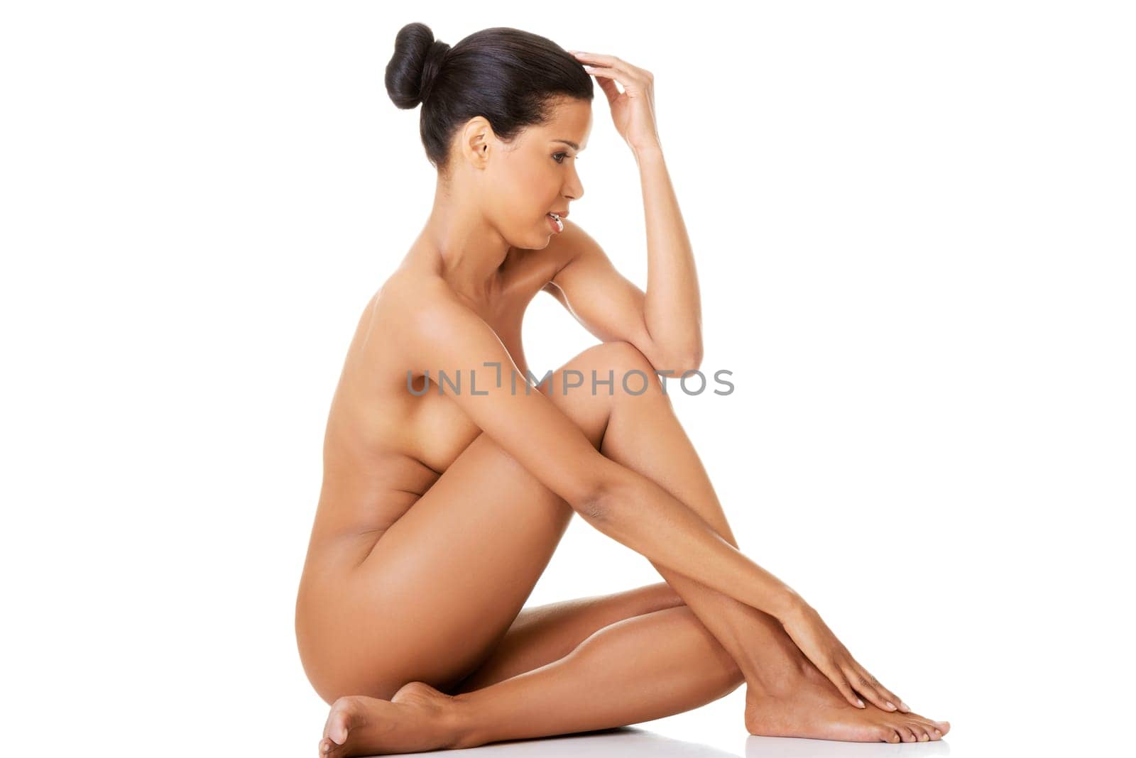 Sexy fit naked woman with healthy clean skin sitting, isolated on white background