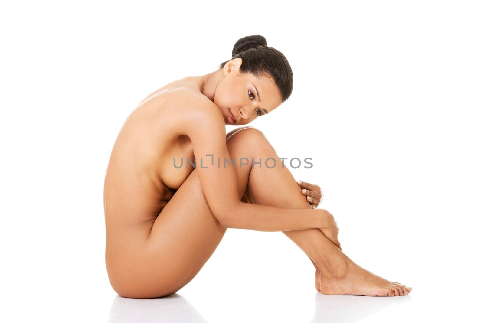 Sexy fit naked woman with healthy clean skin sitting, isolated on white background