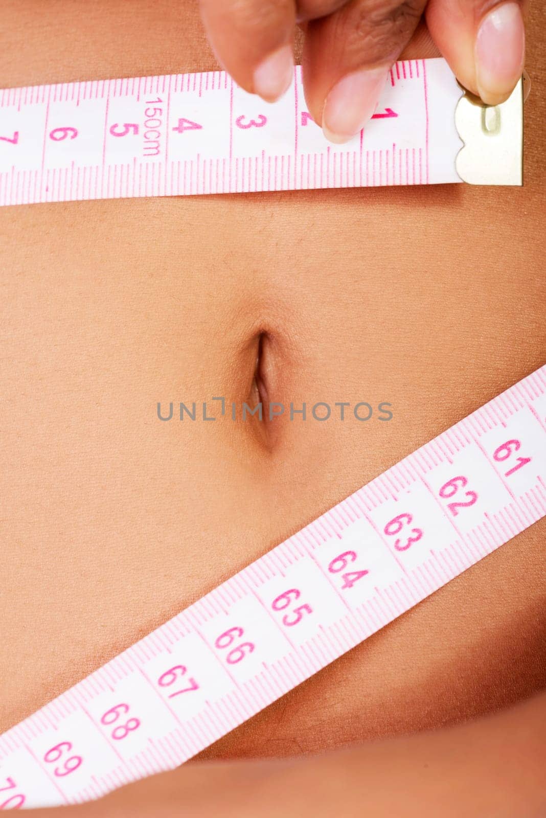Slim fit woman with measure tape measuring her waist , isolated on white background