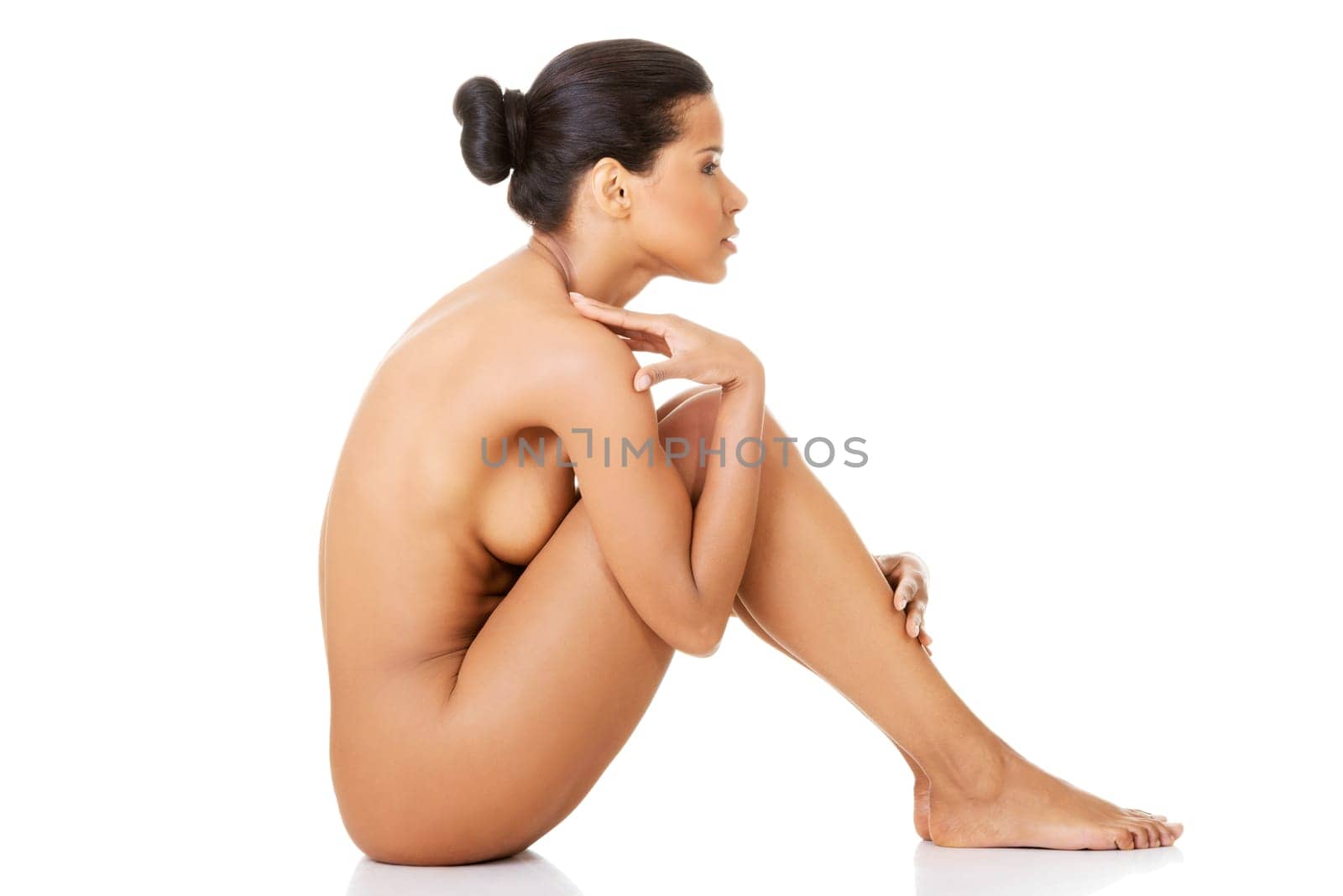 Sexy fit naked woman with healthy clean skin sitting, isolated on white background