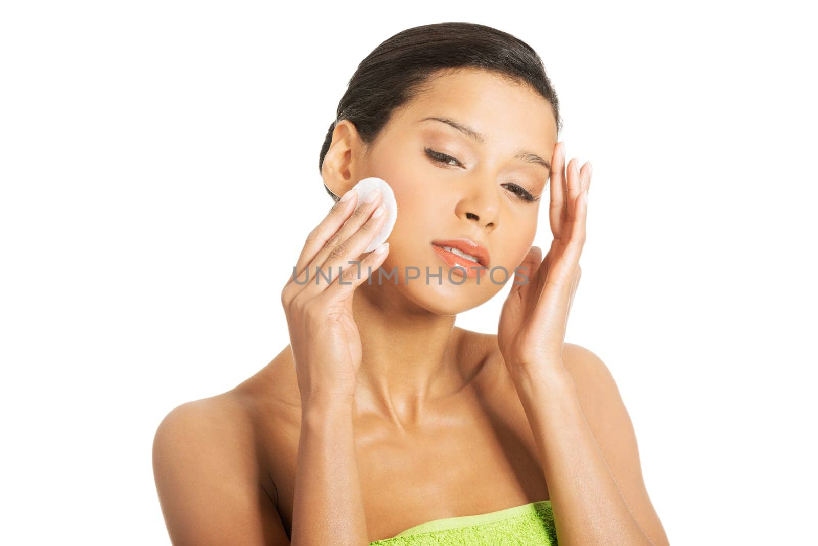 Portrait of happy young woman cleaning skin by cotton pad, over white background