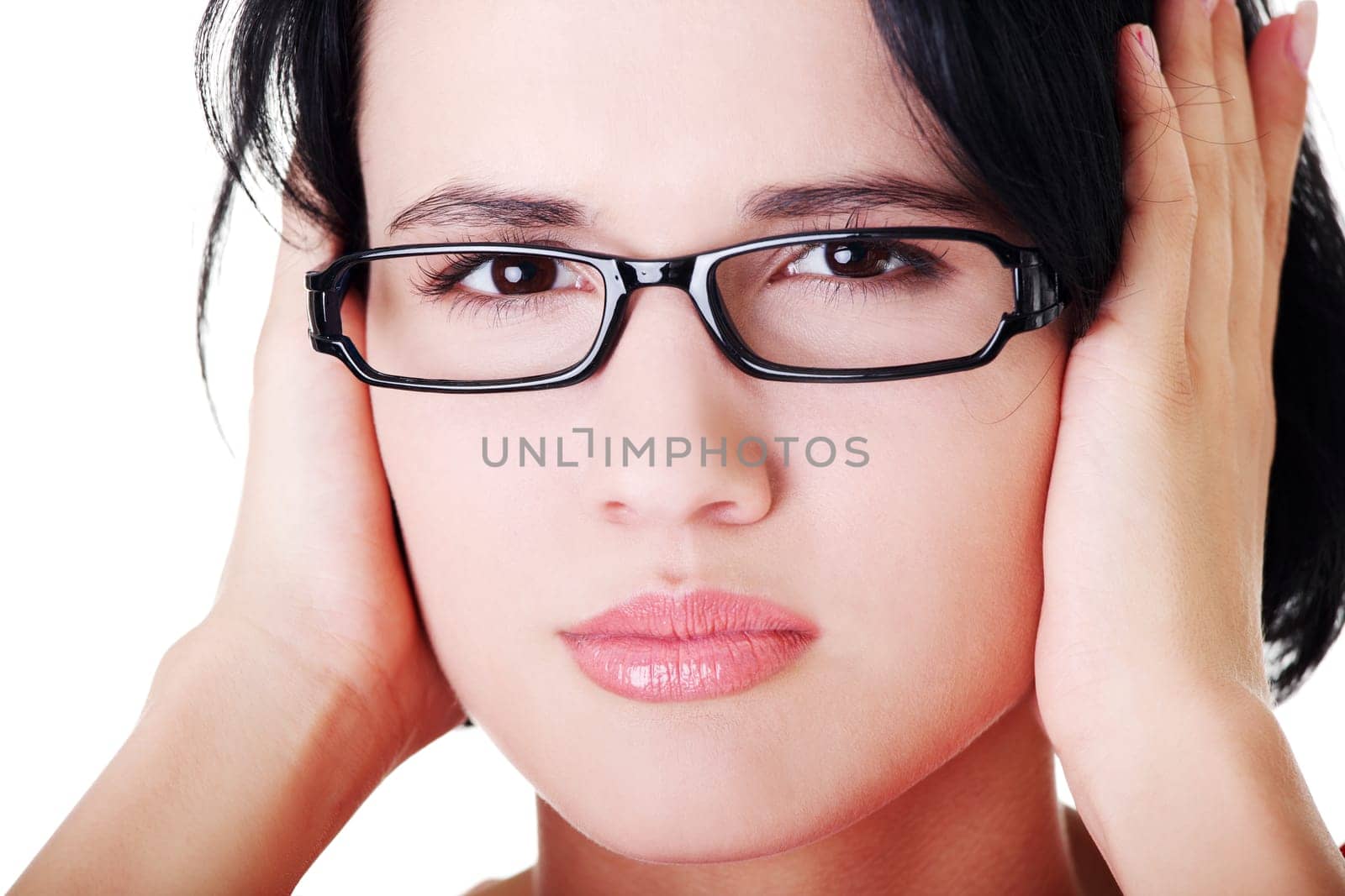 Closeup of frustrated young woman holding her ears, isolated on white