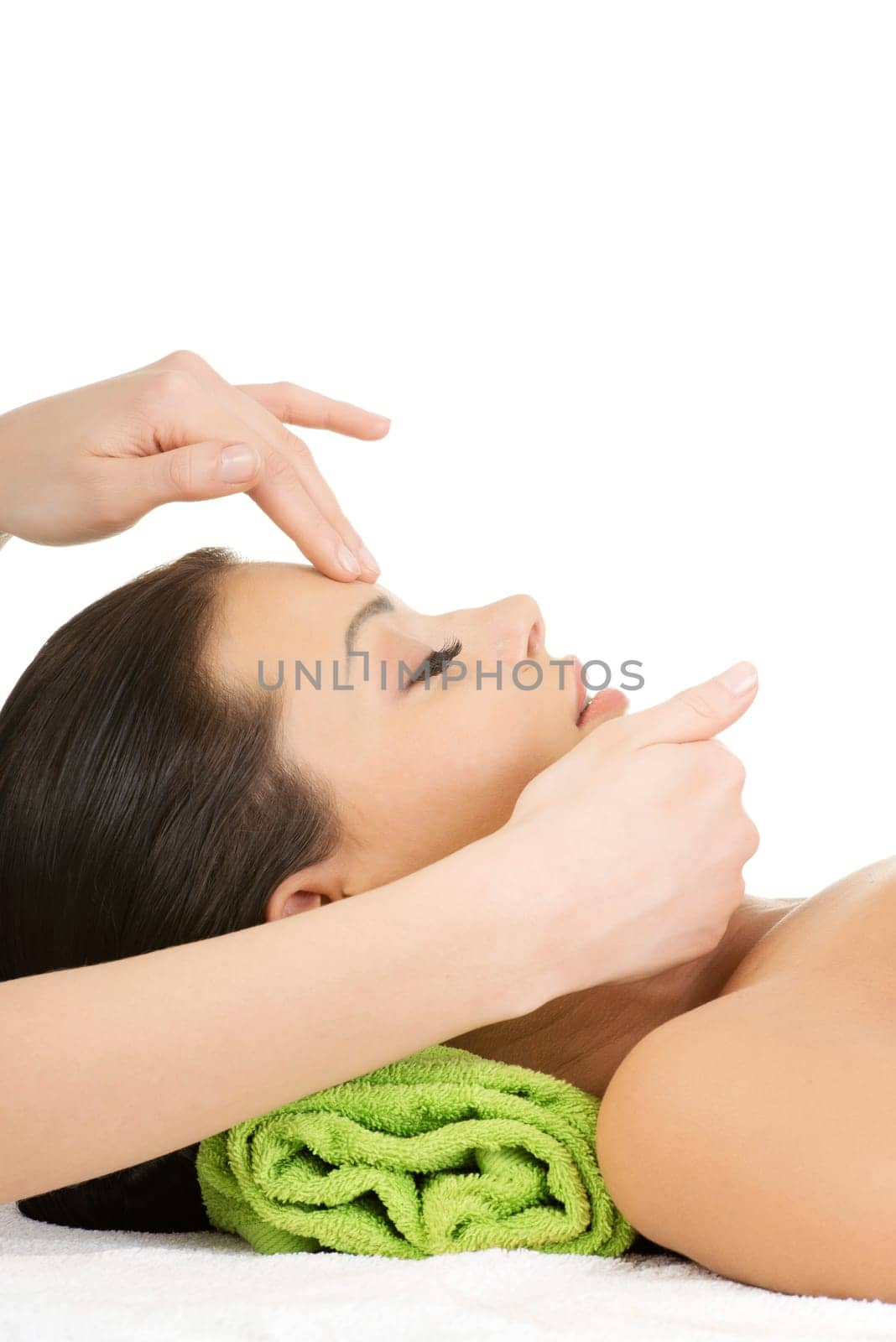 Beautiful young relaxed woman enjoy receiving face massage at spa saloon