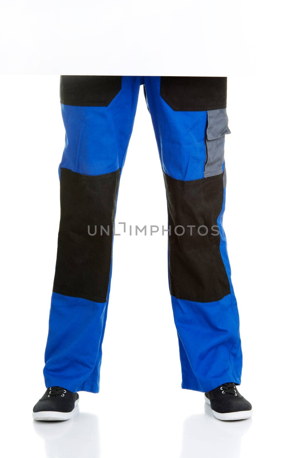 Legs of construction worker behind blank board.
