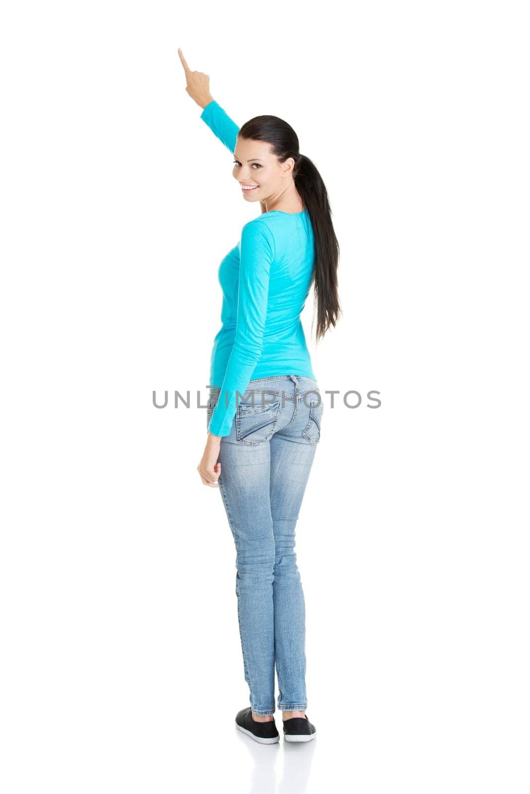 Happy , excited young woman pointing on copy space, isolated on white