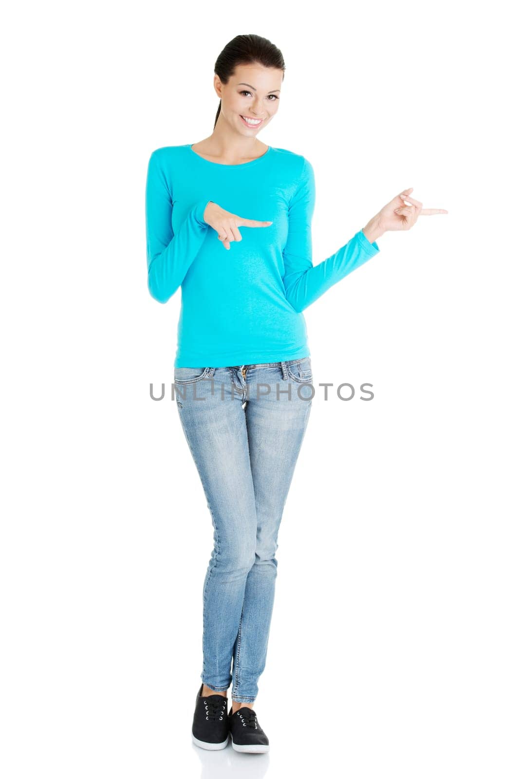 Happy , excited young woman pointing on copy space, isolated on white