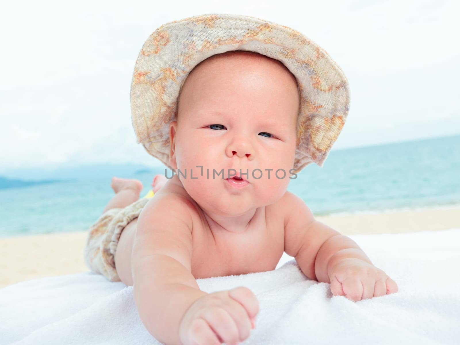 Cure baby laying on the sunbed at the beach