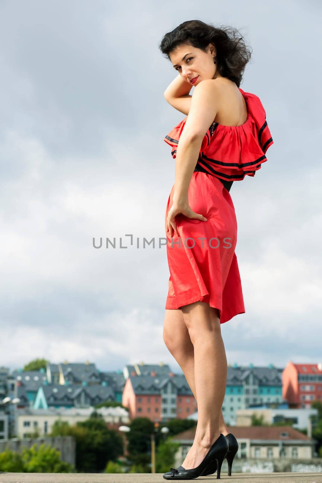 Woman in nice dress posing on city background