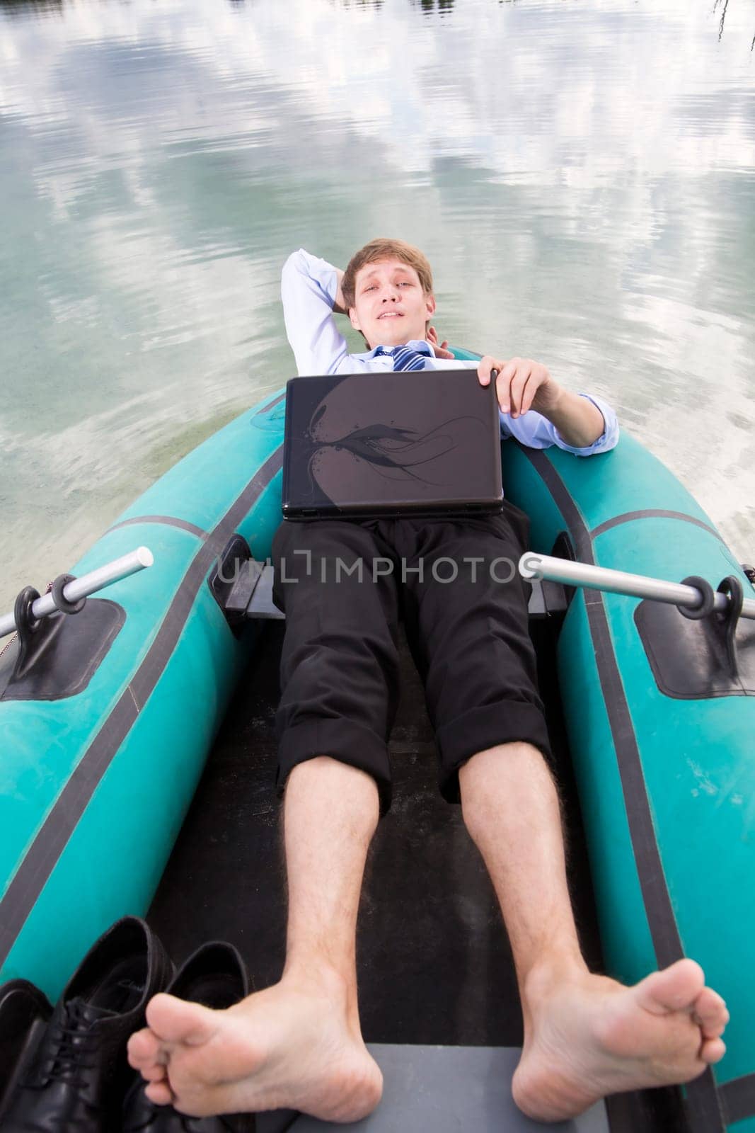 Dressed man lay in boat and take time