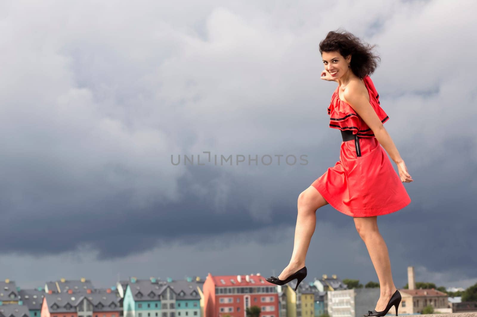 Woman in nice dress stepping on background house