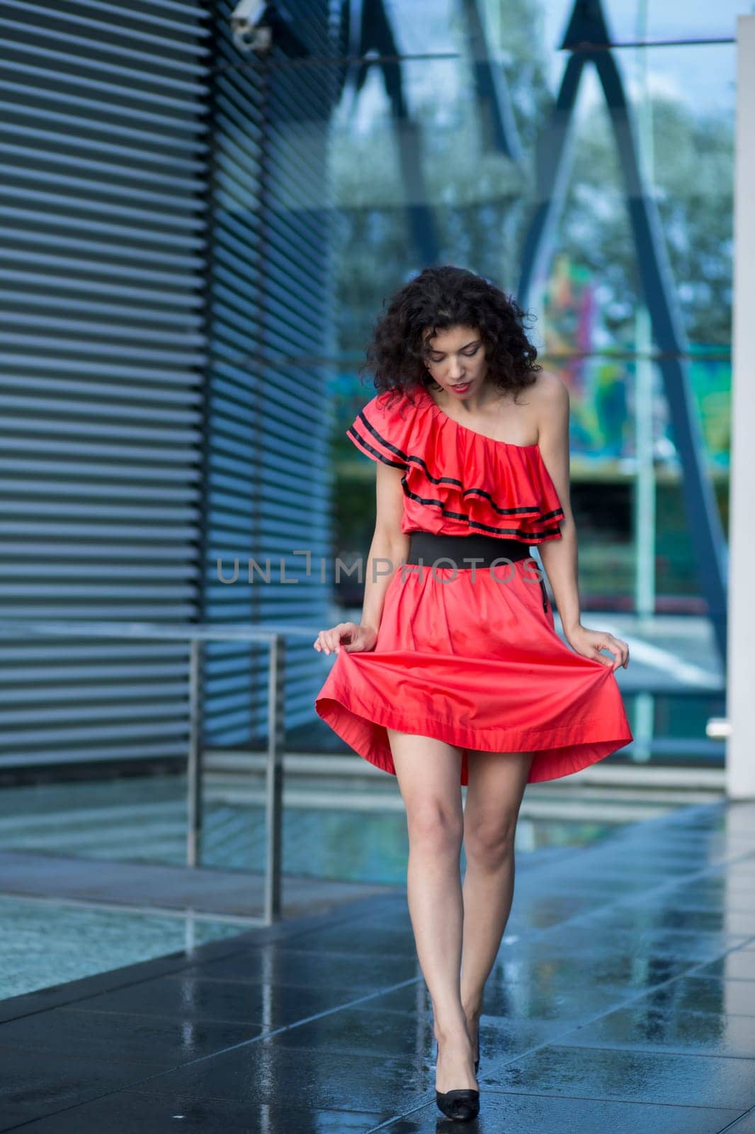 Woman in nice dress walking on wet square