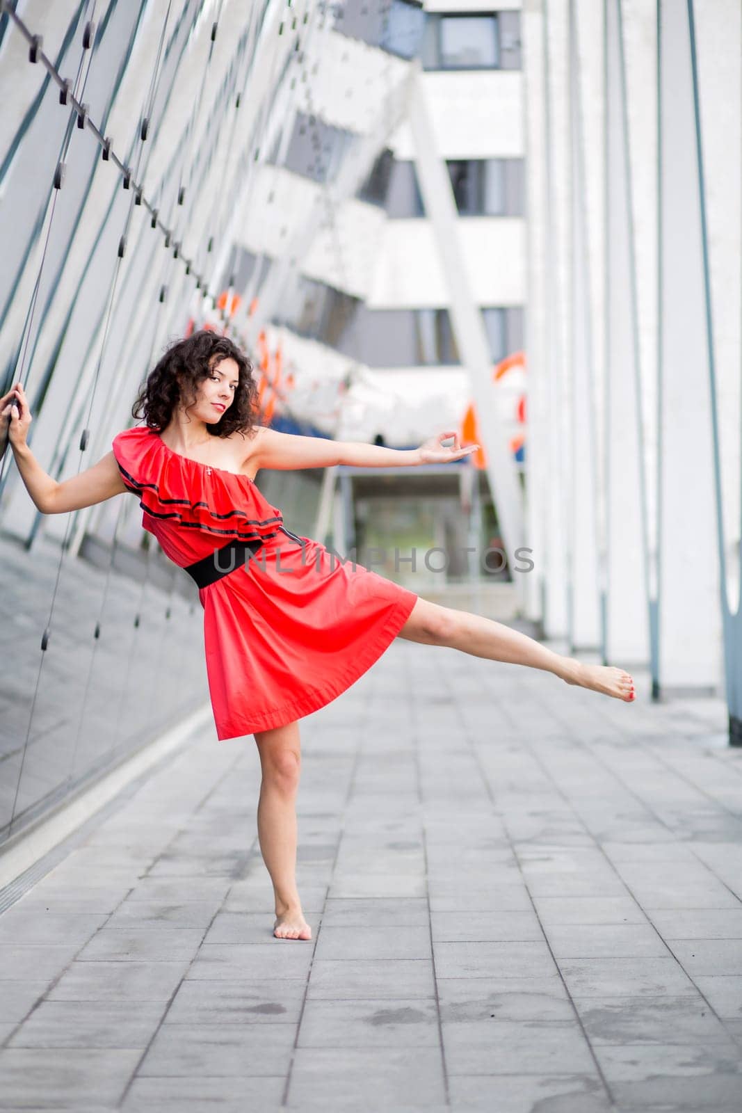 Woman in red dress posing on one leg