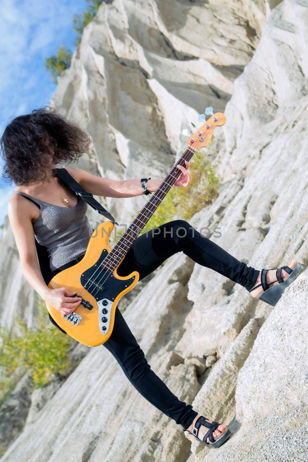Angle view of woman with yellow bass guitar