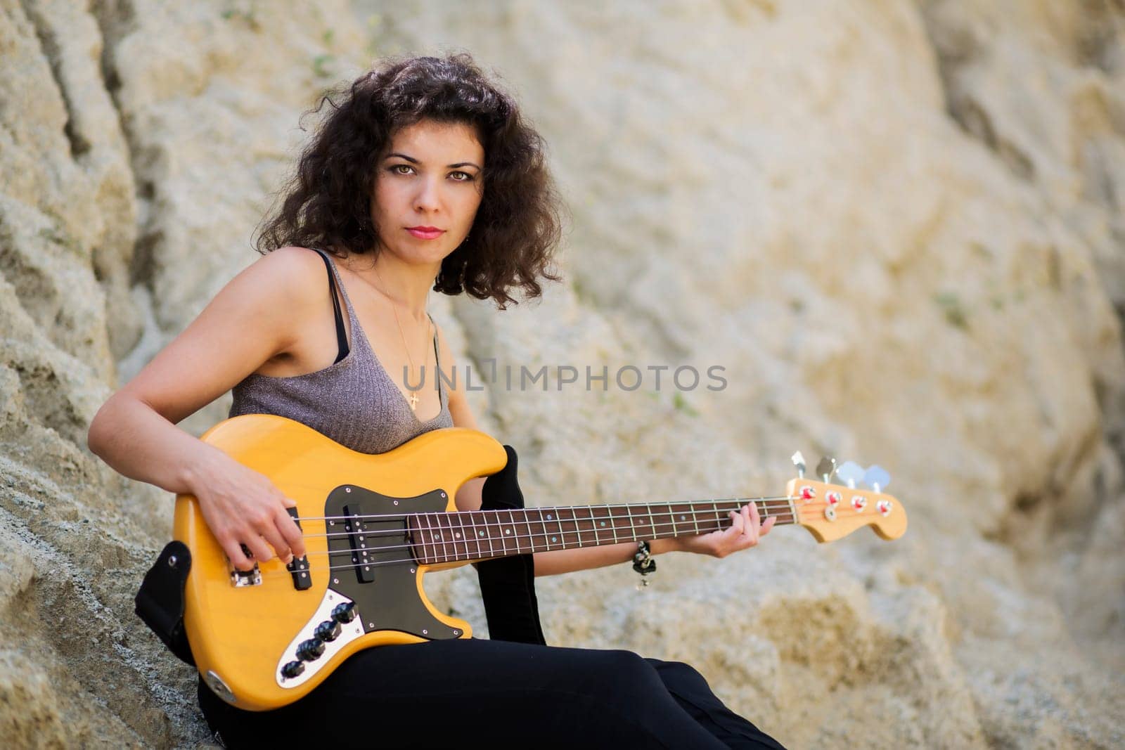 Nice looking young woman sitting next to mountain