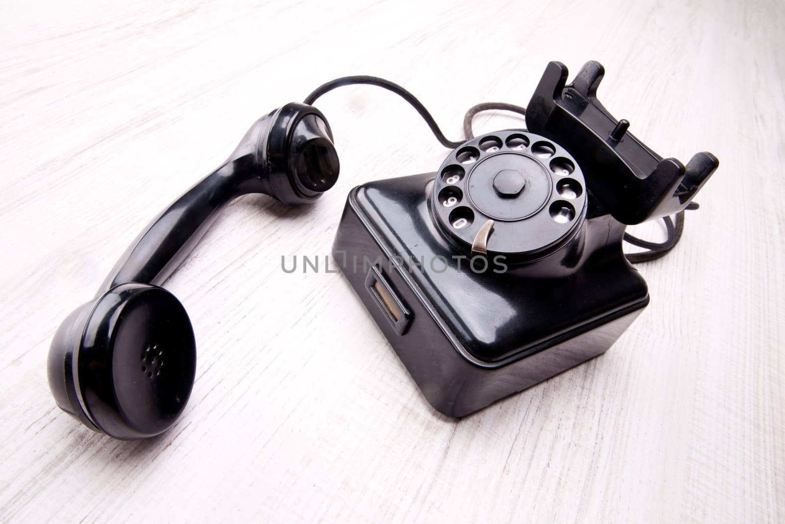 Black rotary dial telephone on a light background