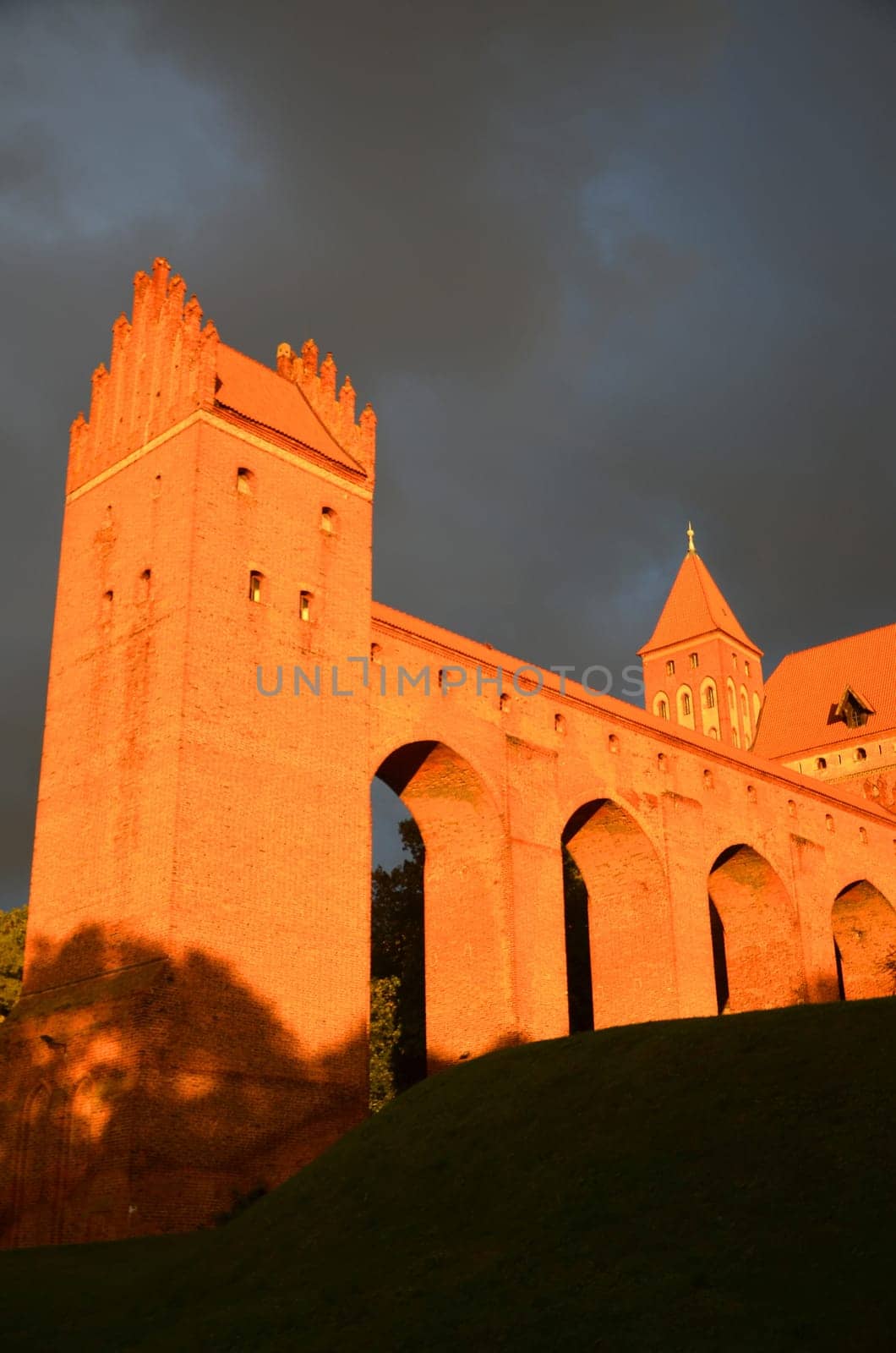 Kwidzyn cathedral in Pomerania region in Poland under dramatic gloomy rainy clouds at sunset