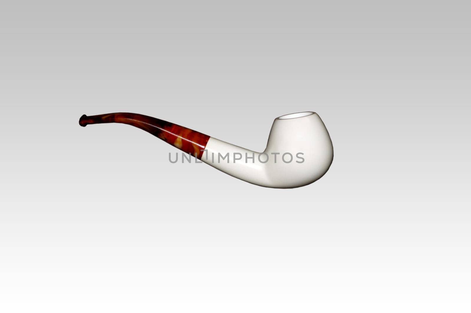 The photograph of an isolated tobacco pipe via top view.